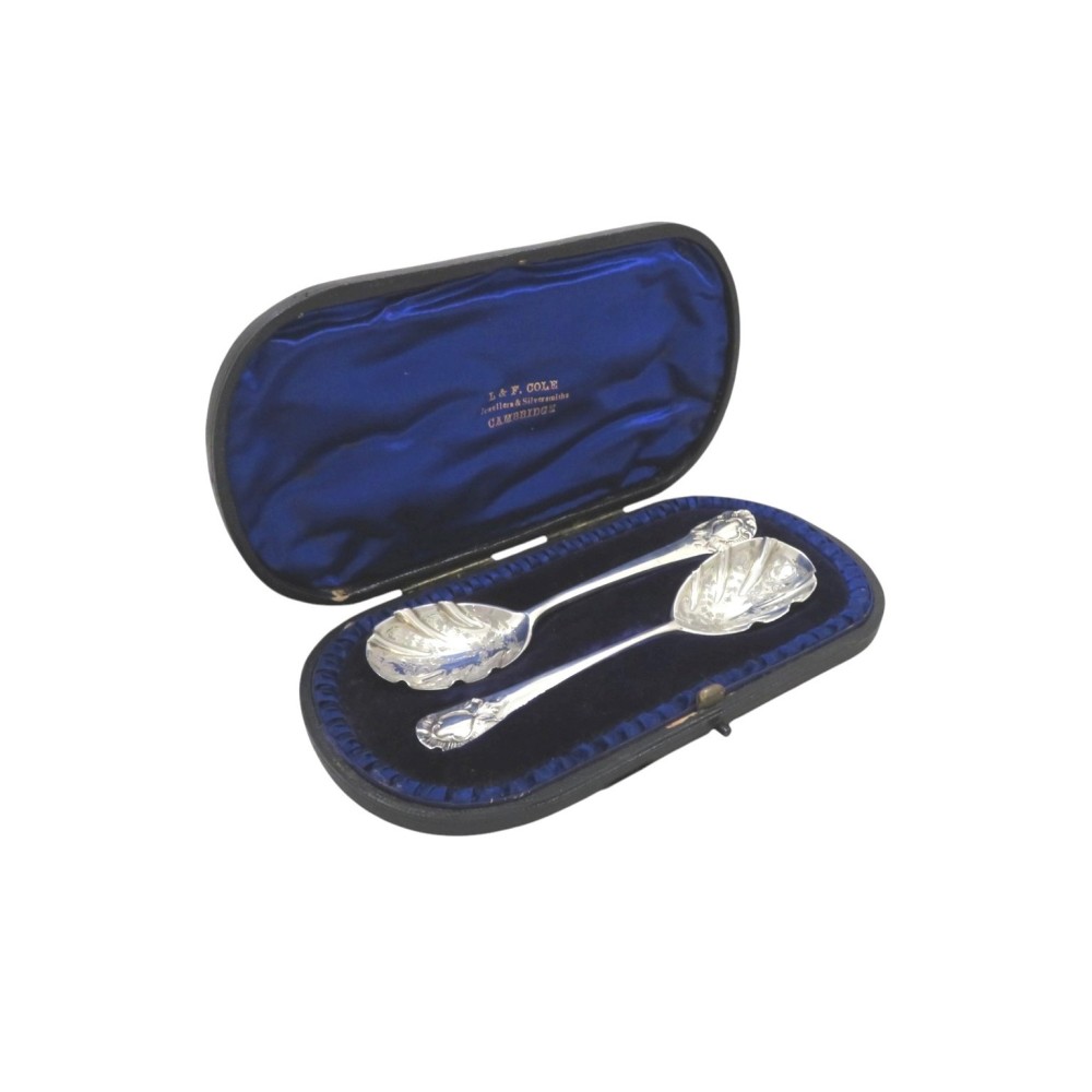 A pair of Victorian sterling silver preserve spoons with fluted shell-form bowls housed inside a blue velvet-lined presentation case.