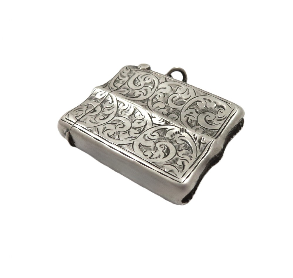 A shaped sterling silver vesta case featuring detailed scrollwork floral engraving, a vacant oval cartouche, and a side suspension ring. View II
