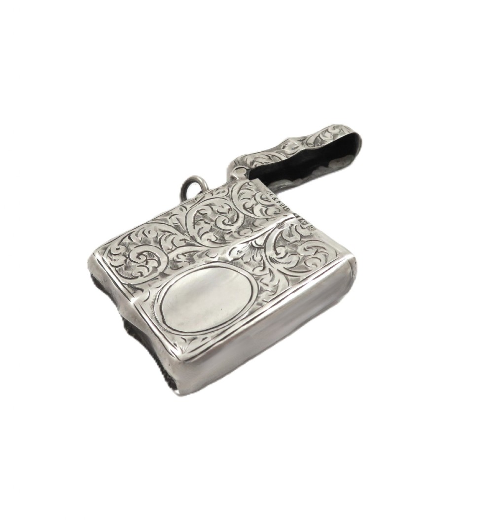 A shaped sterling silver vesta case featuring detailed scrollwork floral engraving, a vacant oval cartouche, and a side suspension ring. View IV