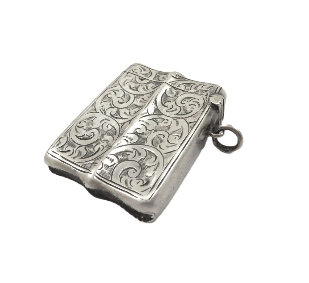 A shaped sterling silver vesta case featuring detailed scrollwork floral engraving, a vacant oval cartouche, and a side suspension ring. View VIII