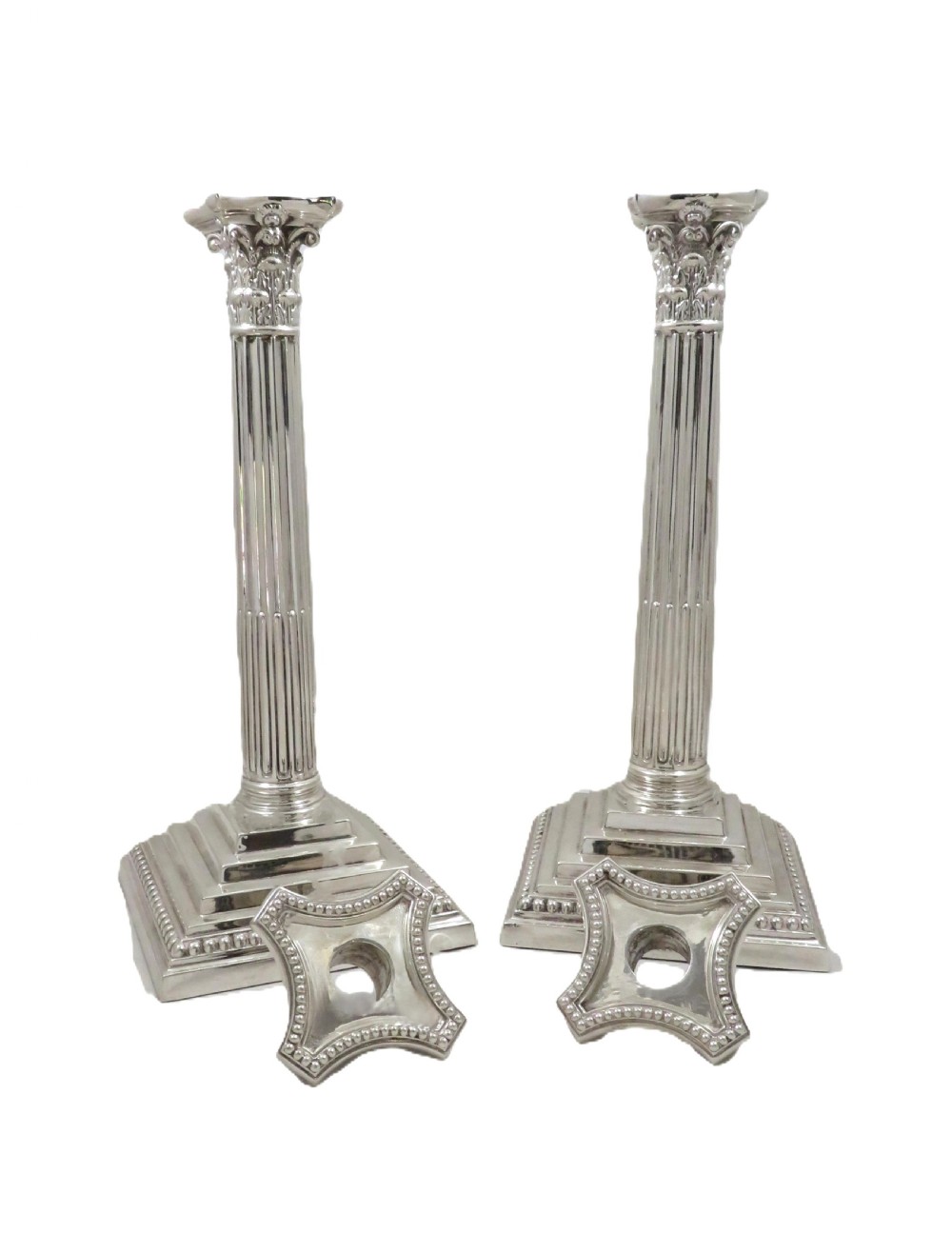 A pair of hallmarked sterling silver candlesticks featuring fluted Corinthian columns and square stepped bases with beaded trim. View VI