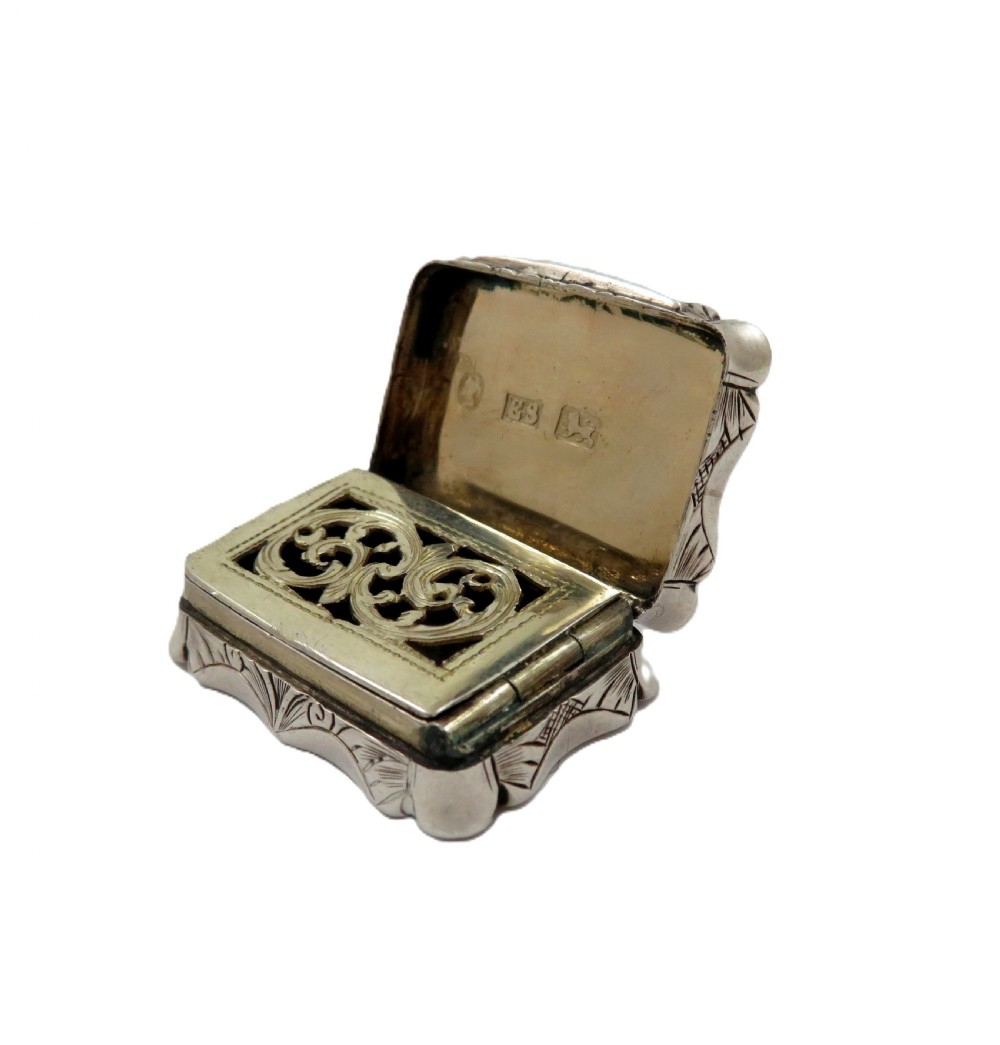 A small rectangular Victorian sterling silver vinaigrette box featuring intricate foliate engraving and a serpentine outline. View VIII