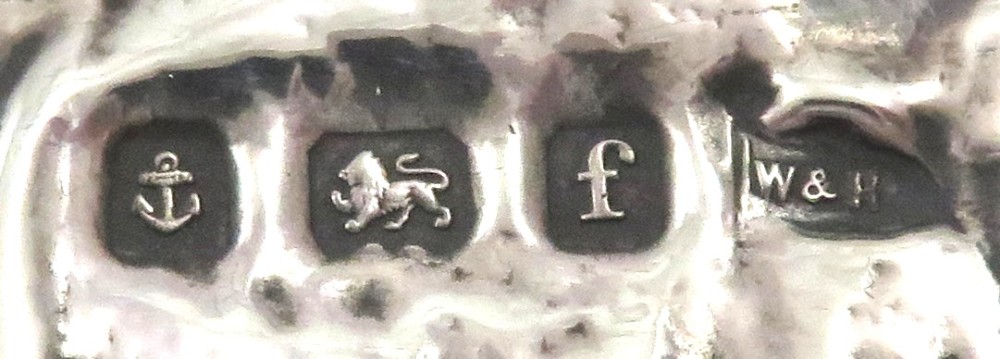 An Art Nouveau sterling silver photo frame featuring an embossed scene of a seated girl beneath a tree with a goat beside a circular opening. View II