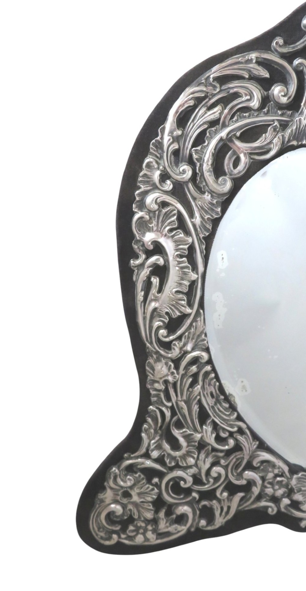 An Edwardian sterling silver dressing table mirror featuring elaborate repousse scrollwork detailing and an easel backing. View VII
