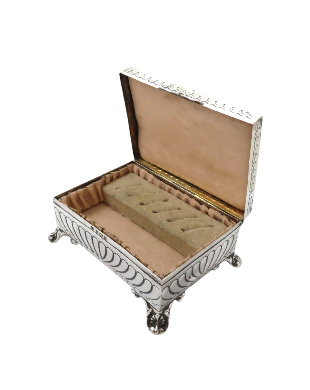 An Edwardian sterling silver rectangular trinket box featuring floral repousse scrollwork on the hinged lid, fluted sides, and small cast feet. View VIII