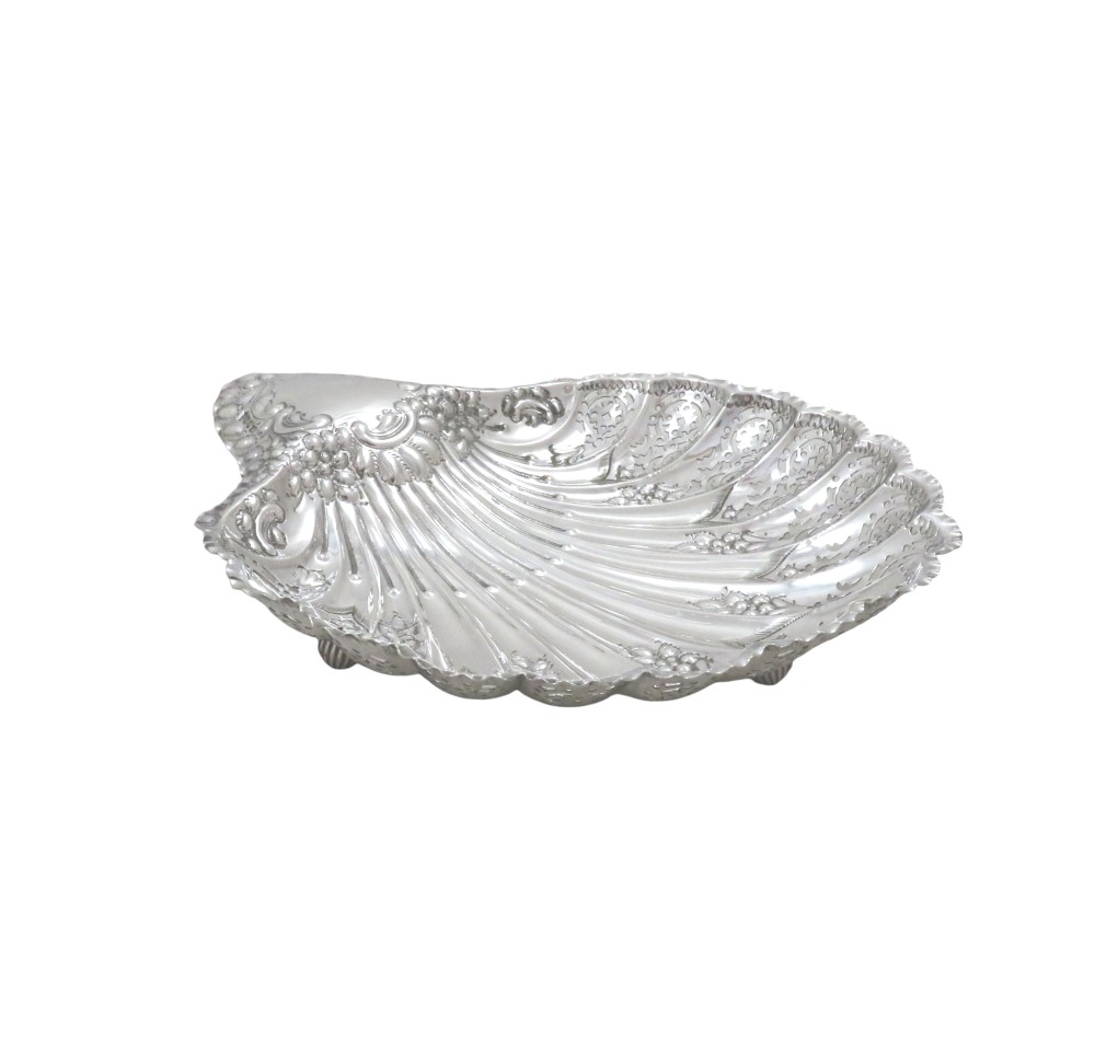 A Victorian sterling silver dish shaped like a scallop shell with intricate repousse foliage and pierced fluted details. View III