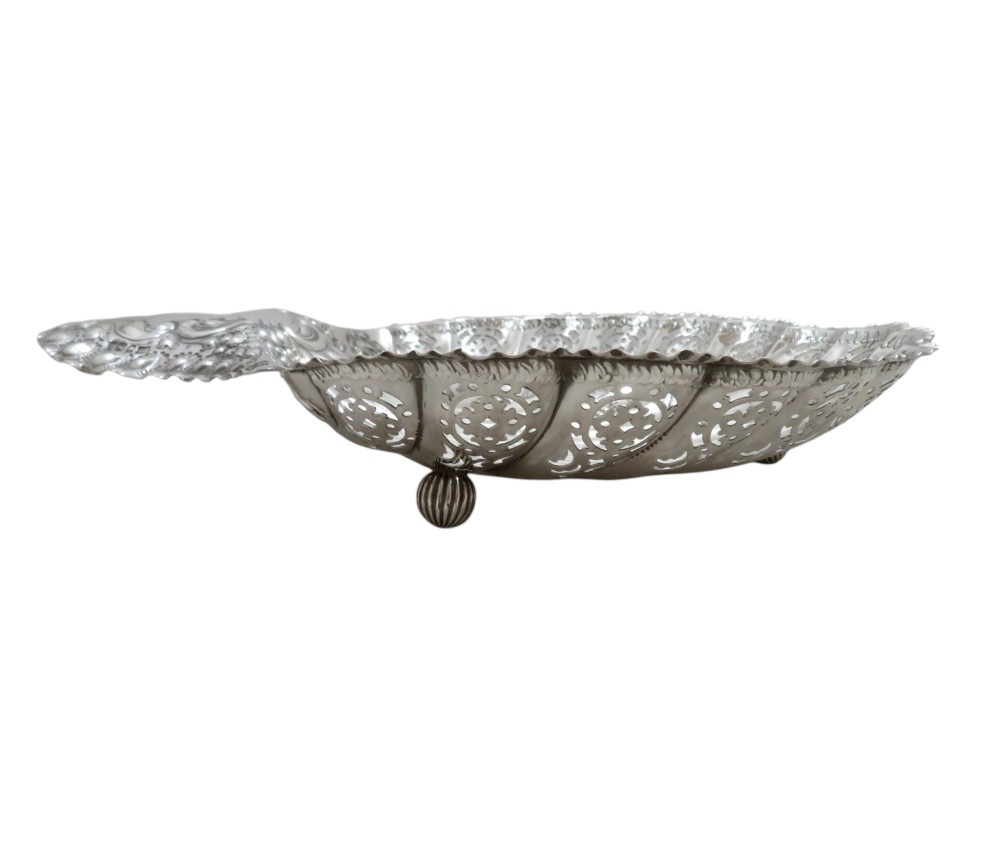 A Victorian sterling silver dish shaped like a scallop shell with intricate repousse foliage and pierced fluted details. View IV