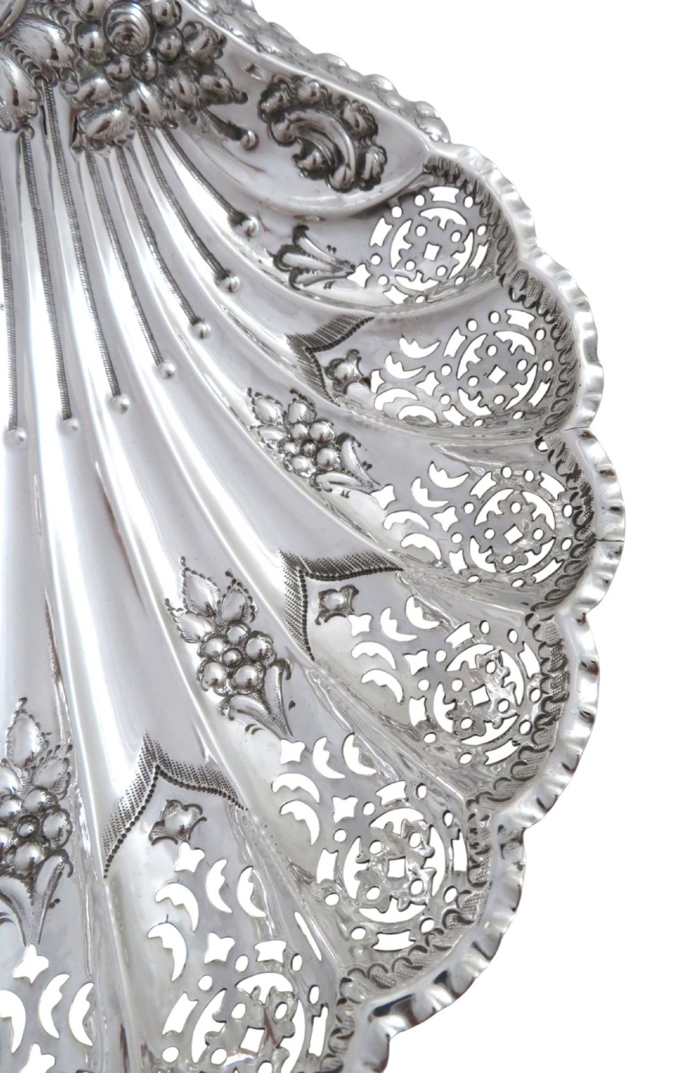 A Victorian sterling silver dish shaped like a scallop shell with intricate repousse foliage and pierced fluted details. View V