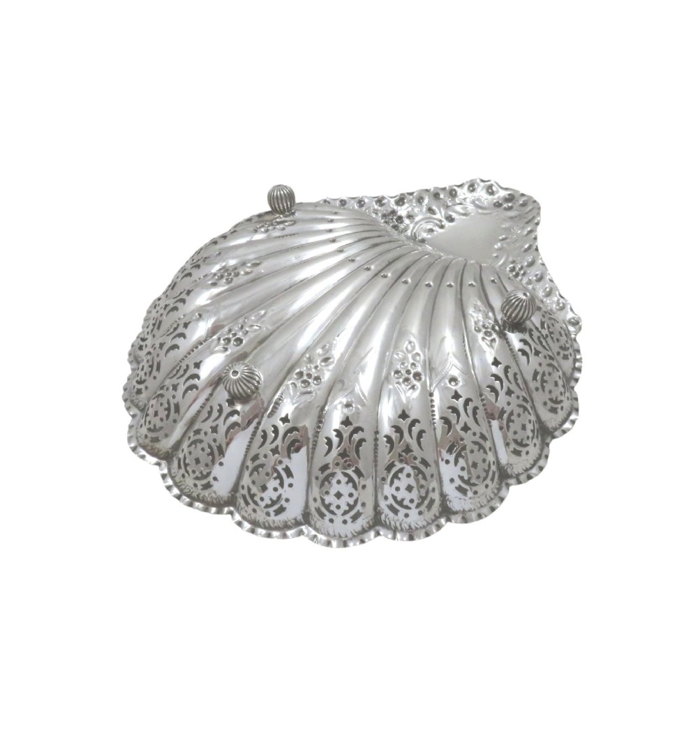 A Victorian sterling silver dish shaped like a scallop shell with intricate repousse foliage and pierced fluted details. View VI