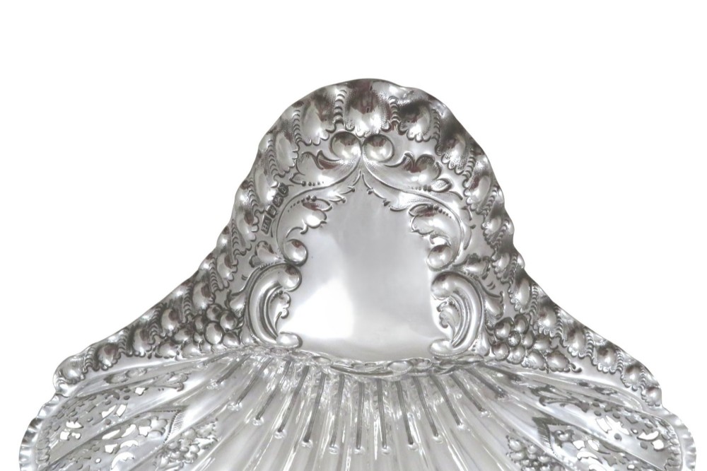 A Victorian sterling silver dish shaped like a scallop shell with intricate repousse foliage and pierced fluted details. View IX