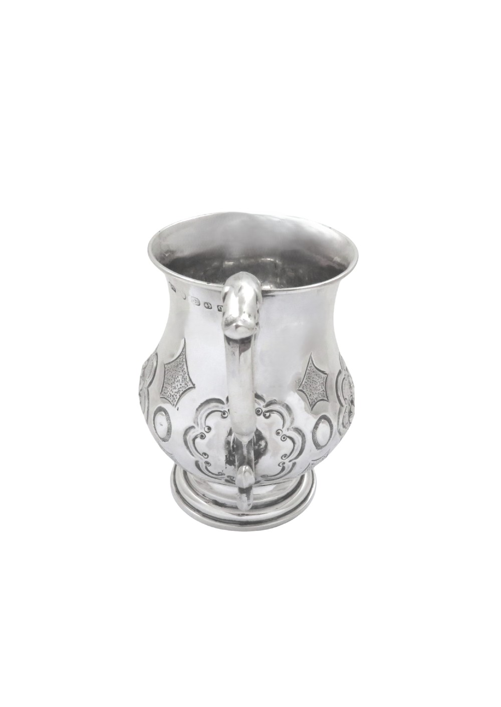 A Victorian sterling silver christening mug featuring floral chasing, geometric embossing, and a scroll handle. View VII