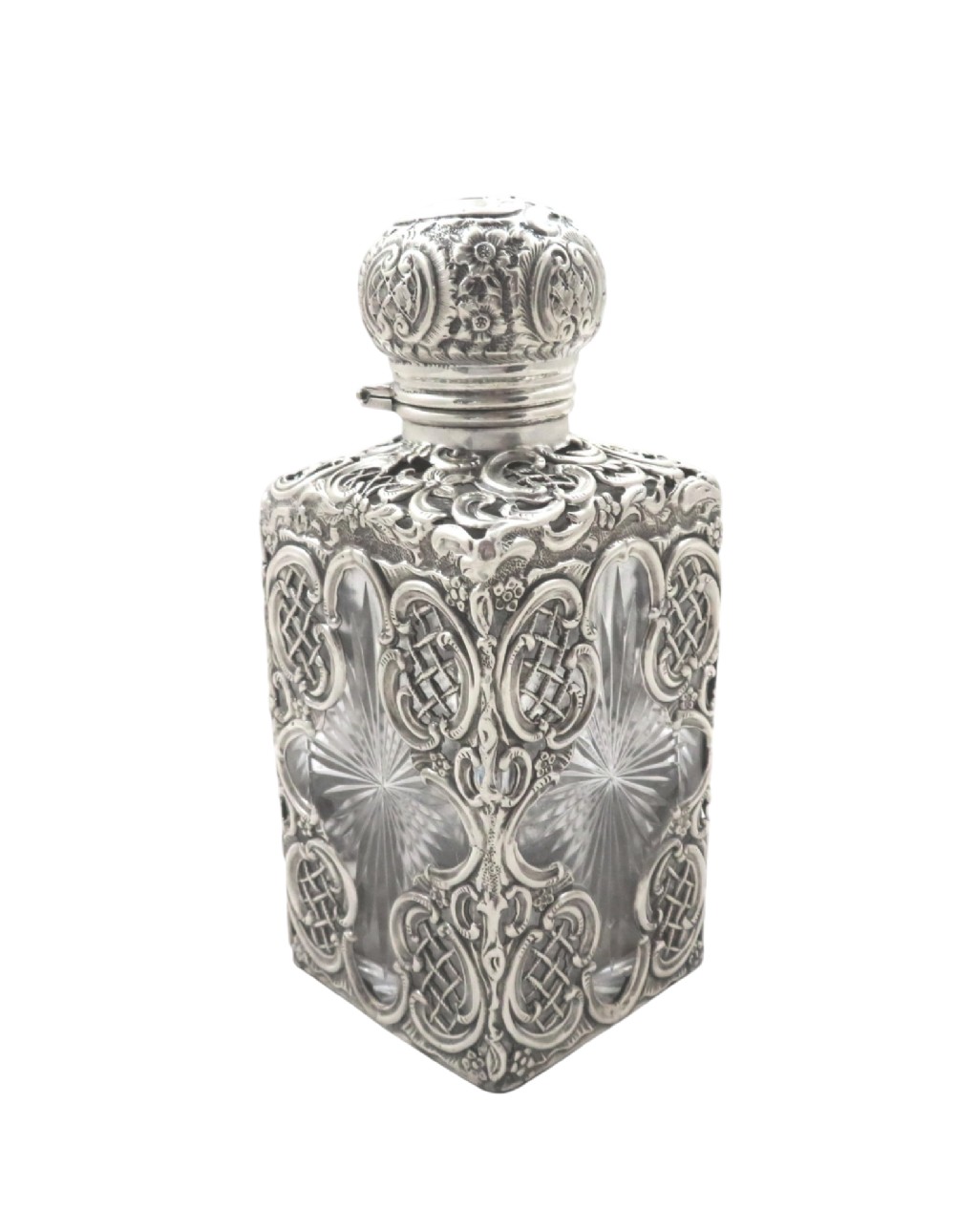 A late Victorian cut-glass scent bottle featuring an intricate pierced sterling silver outer scrollwork overlay and a silver embossed cap. View VI