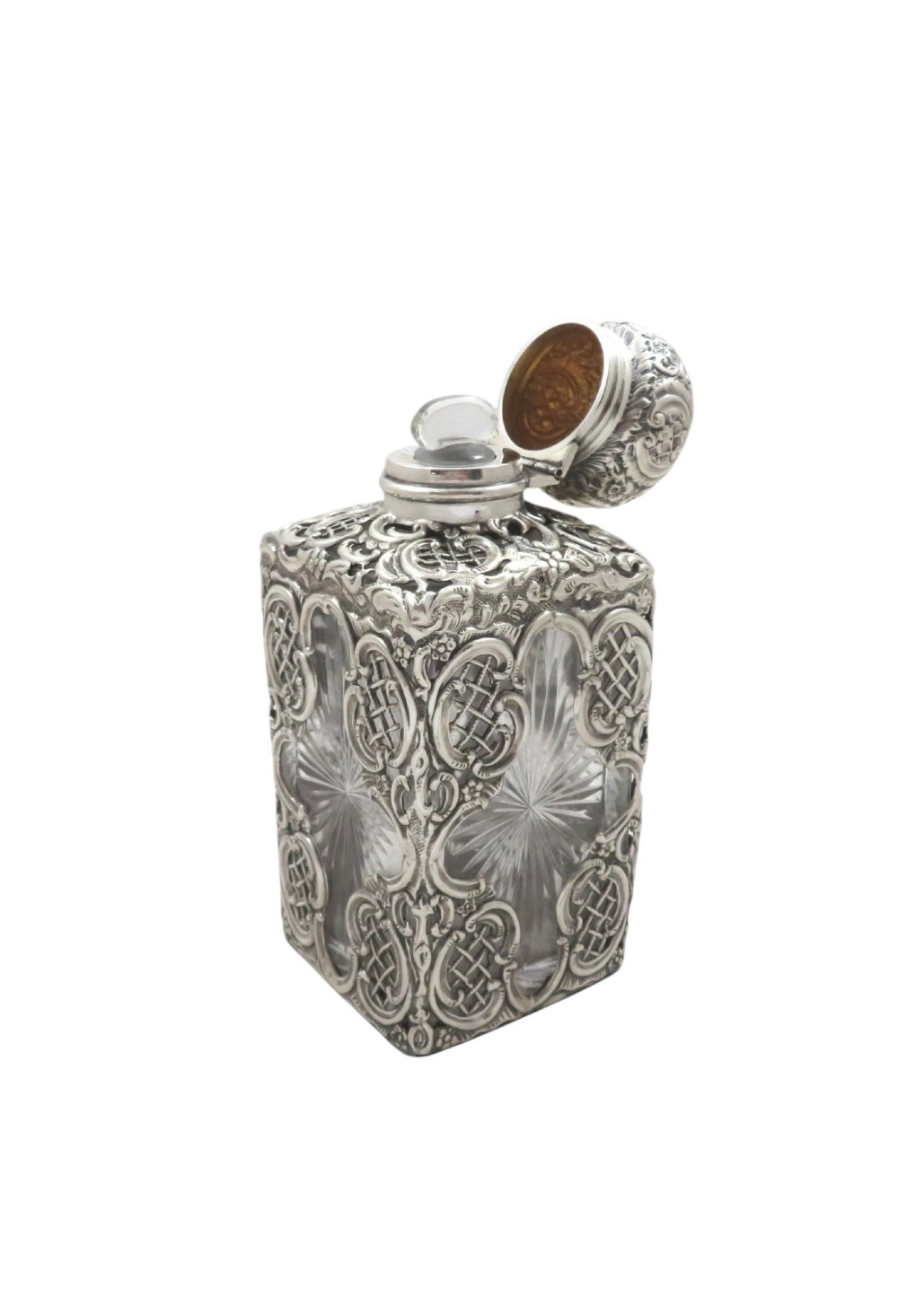 A late Victorian cut-glass scent bottle featuring an intricate pierced sterling silver outer scrollwork overlay and a silver embossed cap. View VII