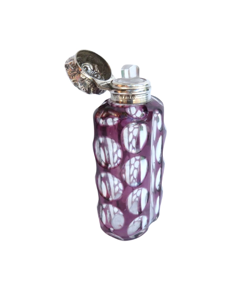 An Edwardian purple overlay cut glass scent bottle with oval clear cutouts and an embossed sterling silver cap. View VI