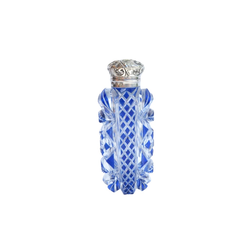 A Victorian blue overlay cut glass scent bottle with an embossed sterling silver top.