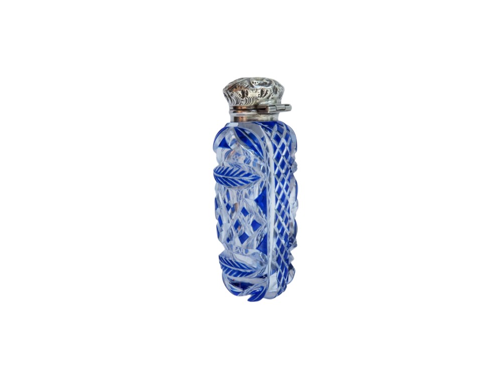 A Victorian blue overlay cut glass scent bottle with an embossed sterling silver top. View V