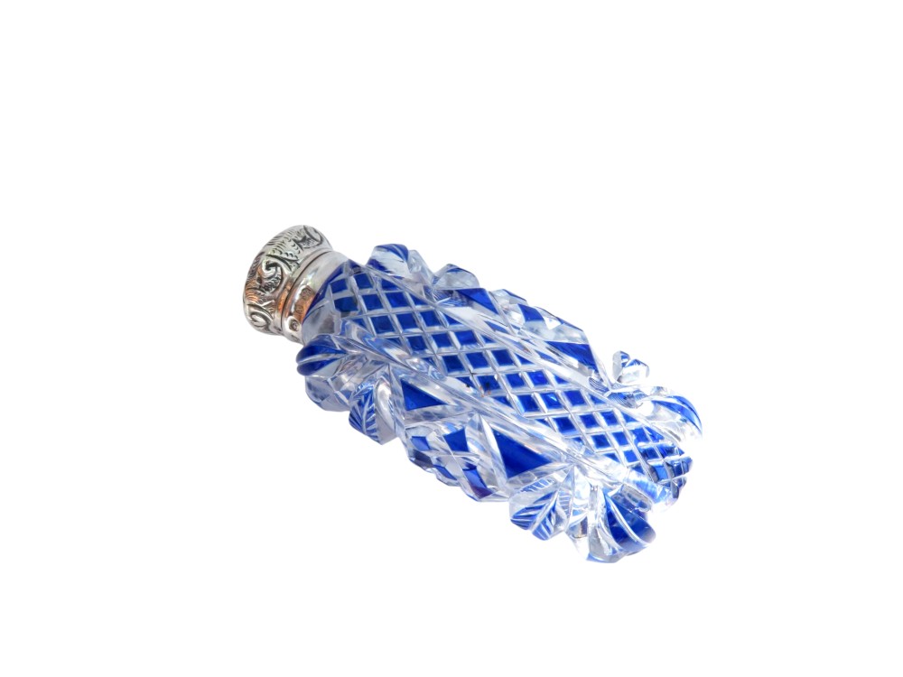 A Victorian blue overlay cut glass scent bottle with an embossed sterling silver top. View VI