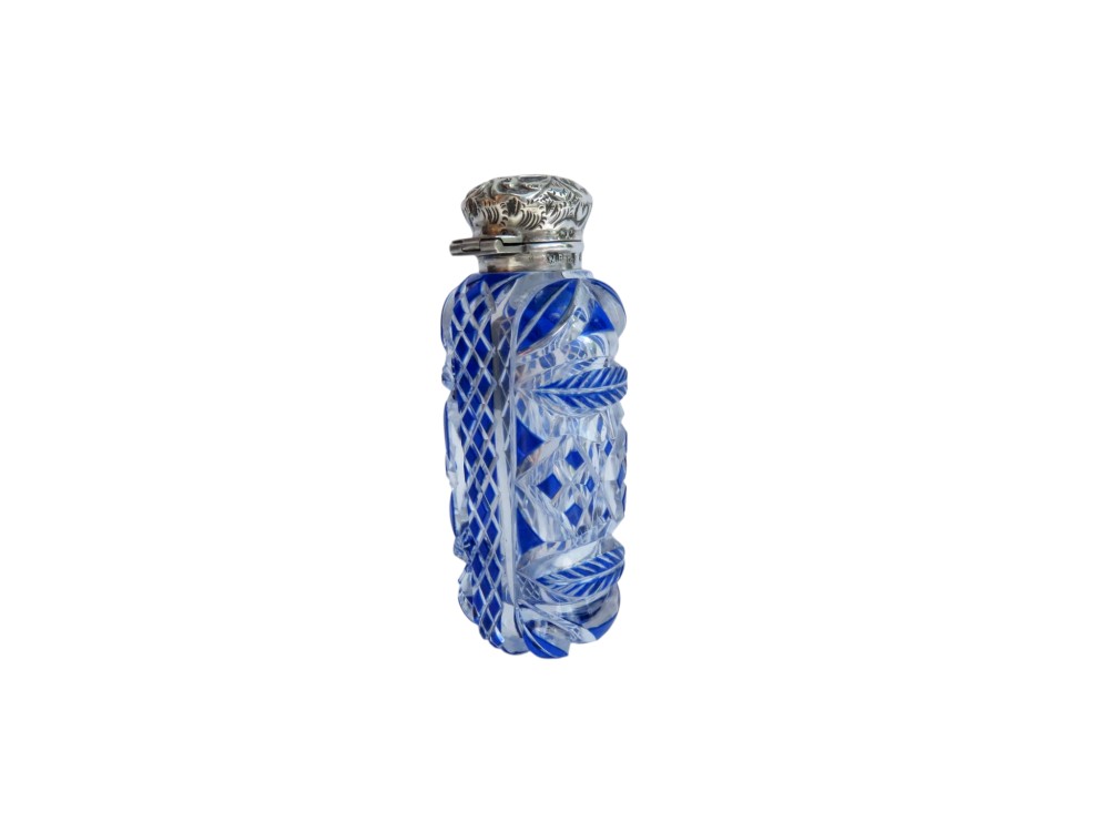 A Victorian blue overlay cut glass scent bottle with an embossed sterling silver top. View IX