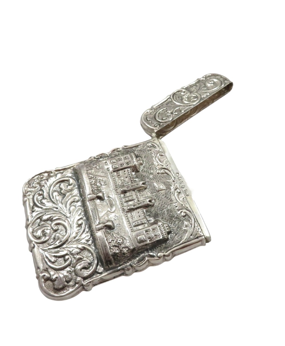 A Victorian sterling silver card case featuring a raised relief depiction of Windsor Castle framed by intricate scrollwork. View VI
