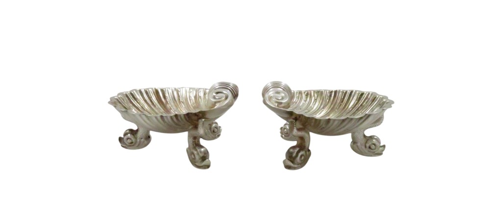 A pair of Victorian sterling silver open salt cellars shaped like scallop shells supported by cast dolphin feet. View VI