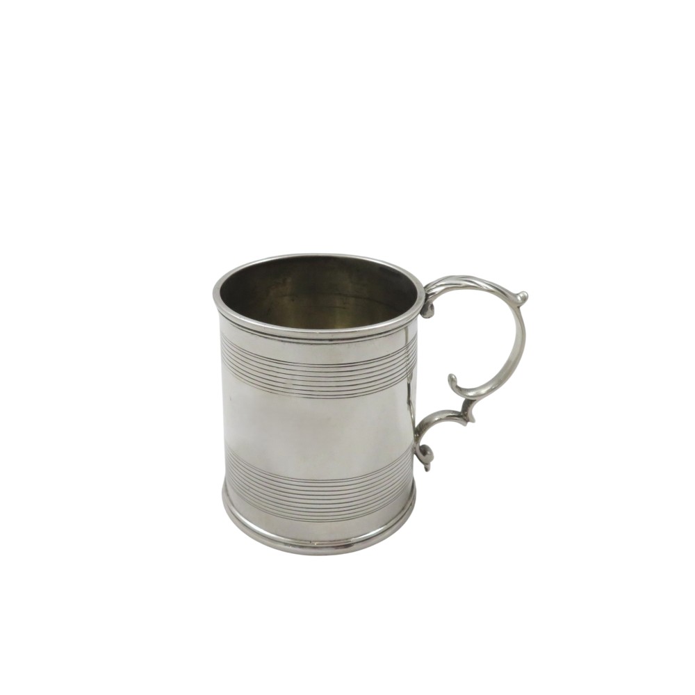 A straight-sided Georgian sterling silver mug featuring reeded horizontal bands and a scroll handle.