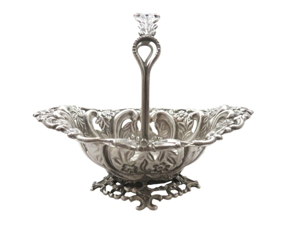 A pair of Edwardian sterling silver baskets featuring pierced floral openwork, swing handles, and scroll feet. View VI