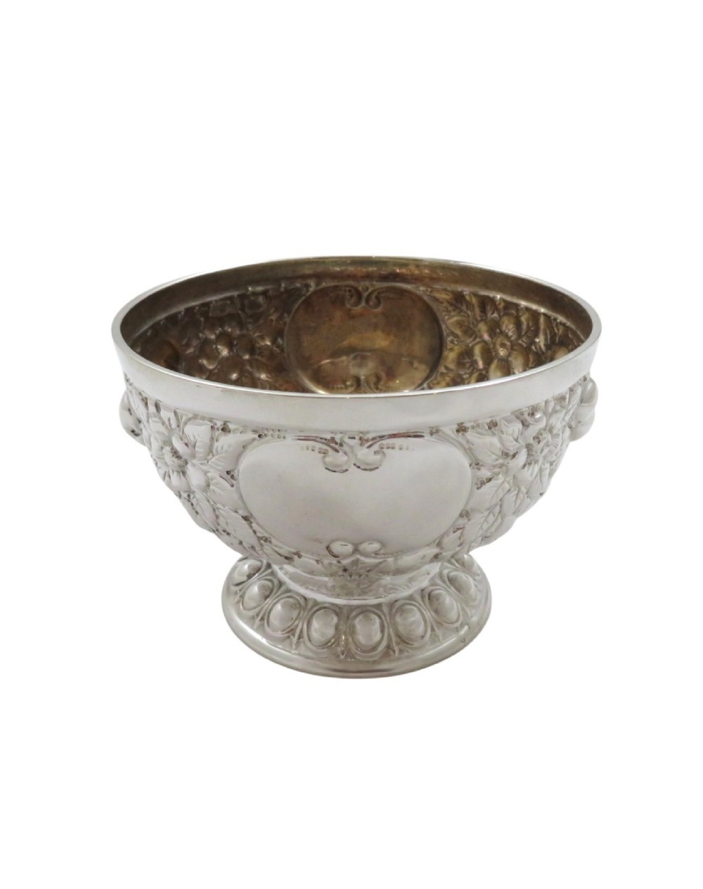 An antique Victorian sterling silver bowl featuring embossed floral motifs, polished cartouches, and a stepped circular pedestal base. View V