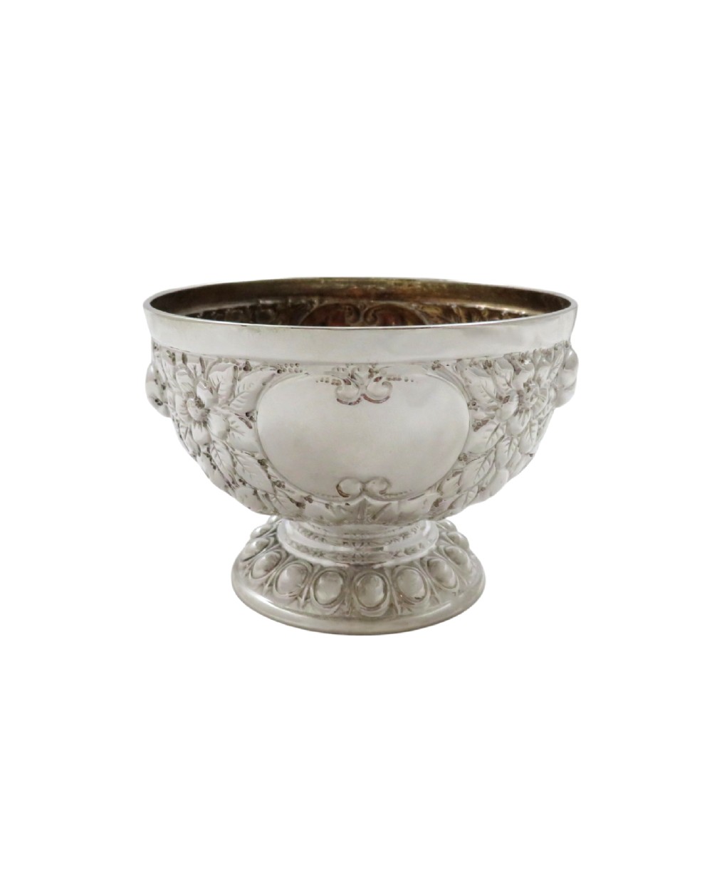 An antique Victorian sterling silver bowl featuring embossed floral motifs, polished cartouches, and a stepped circular pedestal base. View VIII