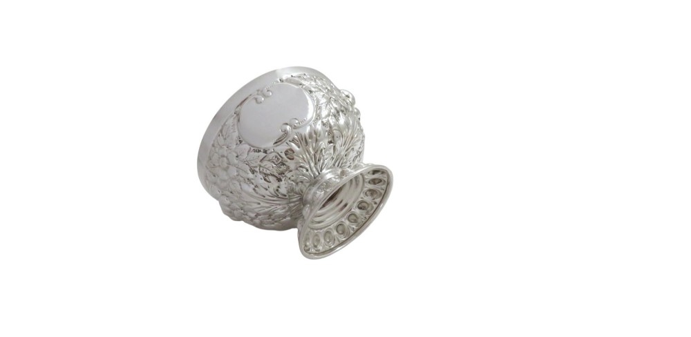 An antique Victorian sterling silver bowl featuring embossed floral motifs, polished cartouches, and a stepped circular pedestal base. View IX