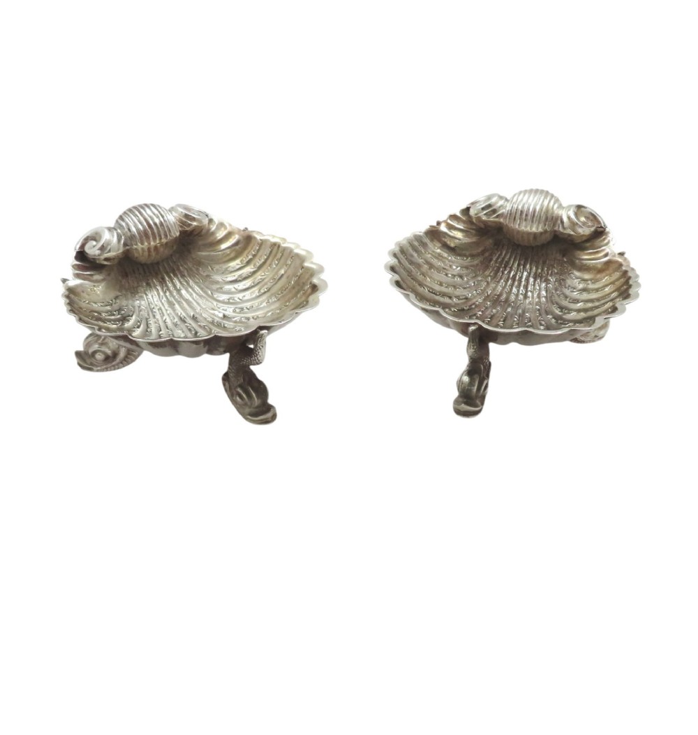 A pair of Victorian sterling silver open salt cellars shaped like scallop shells with ornate cast feet. View V
