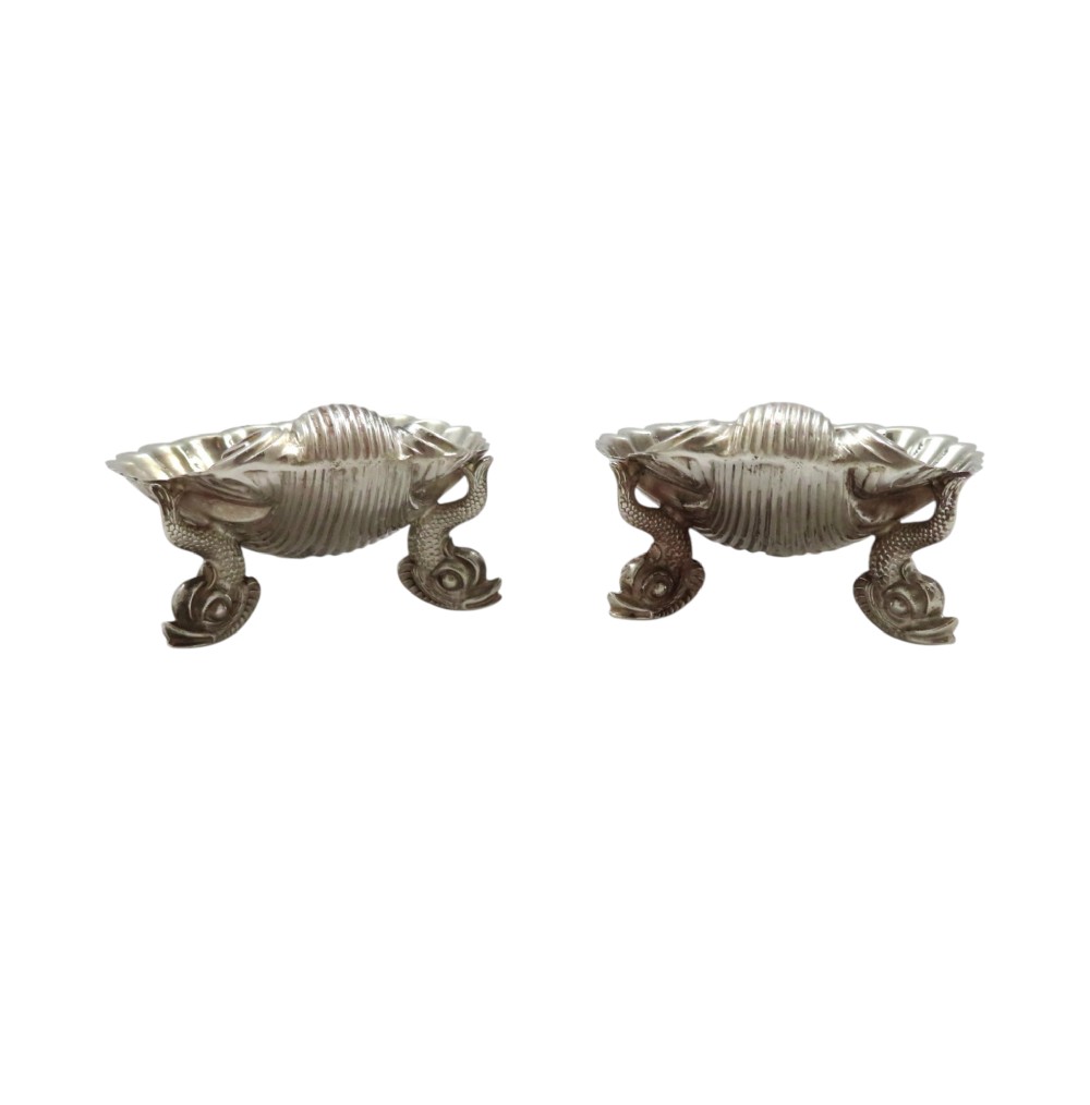 A pair of Victorian sterling silver open salt cellars shaped like scallop shells with ornate cast feet. View VI