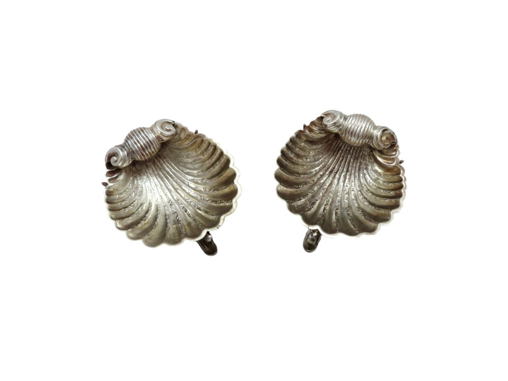 A pair of Victorian sterling silver open salt cellars shaped like scallop shells with ornate cast feet. View VIII