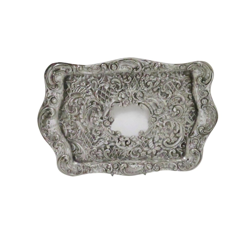 A rectangular Edwardian sterling silver dressing tray featuring ornate repousse scrollwork, lattice patterns, and a central unengraved cartouche.