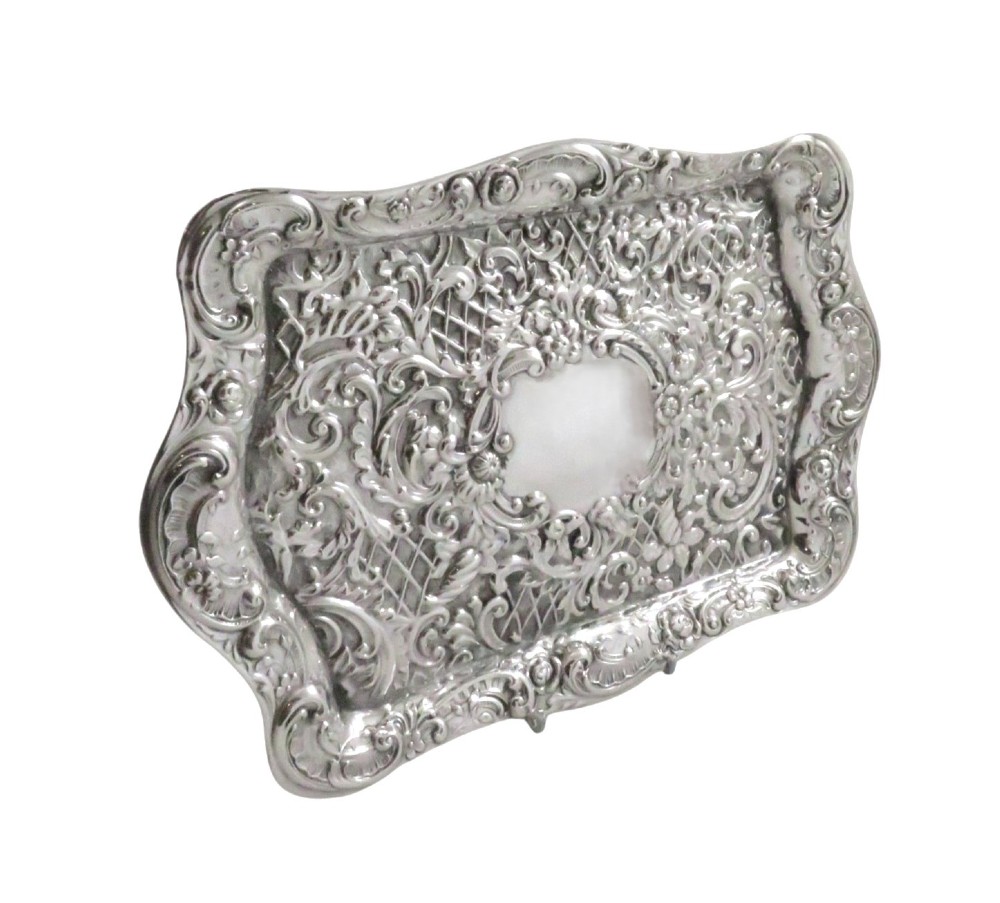 A rectangular Edwardian sterling silver dressing tray featuring ornate repousse scrollwork, lattice patterns, and a central unengraved cartouche. View IV