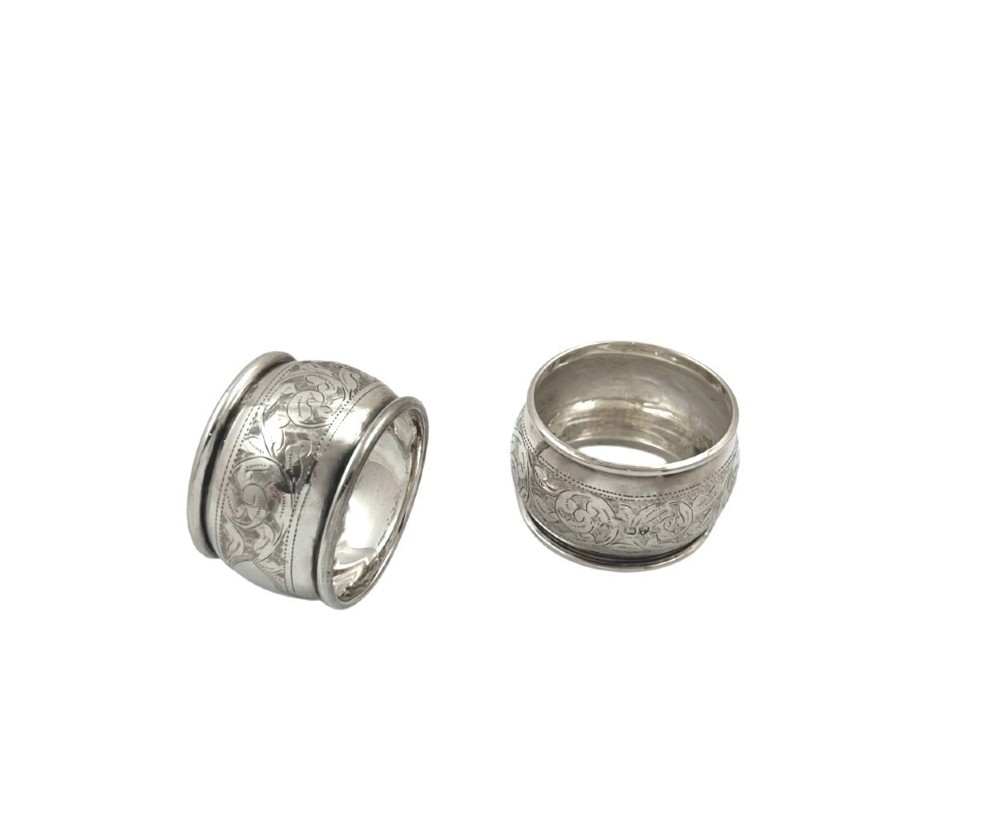 A set of six engraved sterling silver napkin rings arranged inside a black fitted presentation case lined with bright blue silk. View IV