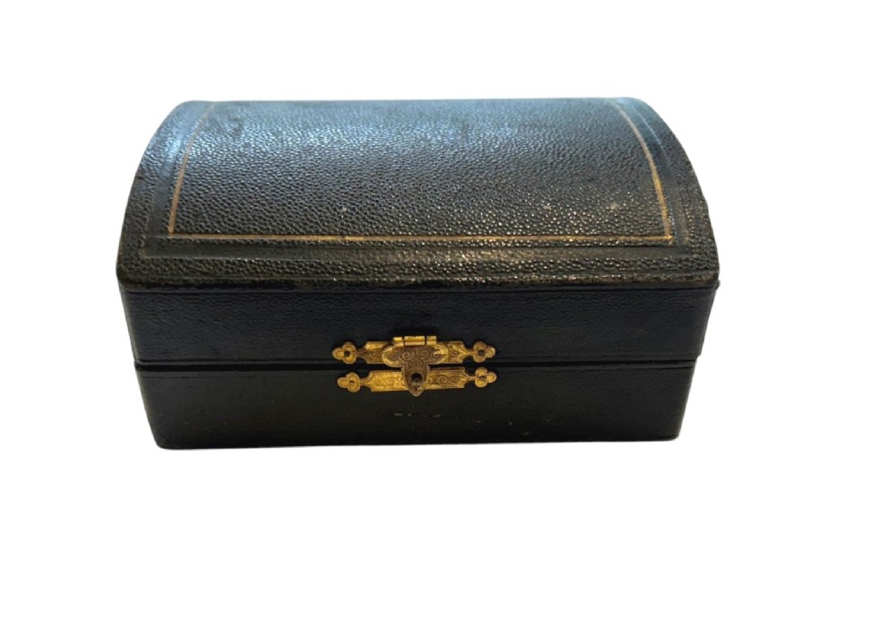 A set of six engraved sterling silver napkin rings arranged inside a black fitted presentation case lined with bright blue silk. View V