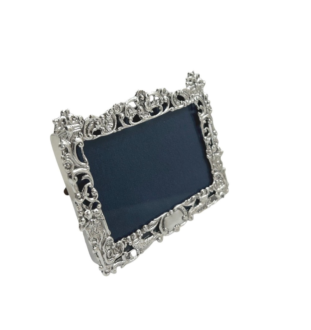An ornate rectangular sterling silver landscape photo frame featuring detailed repousse scrollwork around the border. View IV