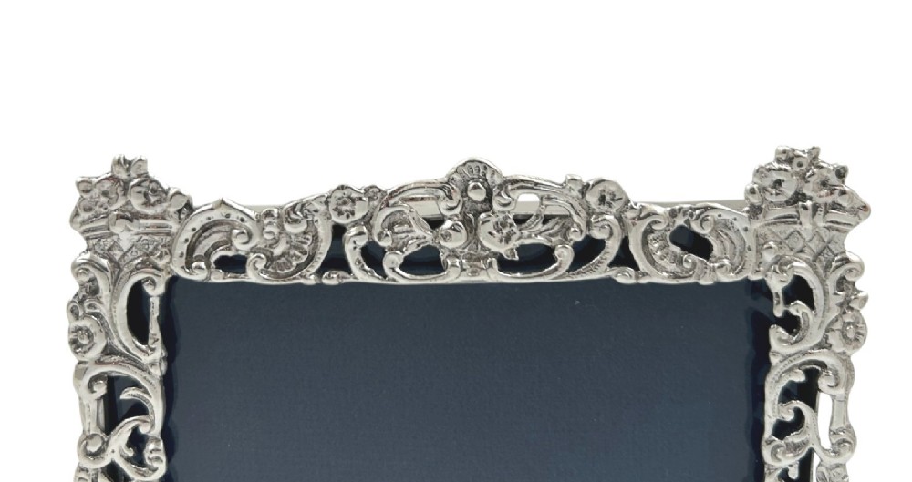 An ornate rectangular sterling silver landscape photo frame featuring detailed repousse scrollwork around the border. View VI