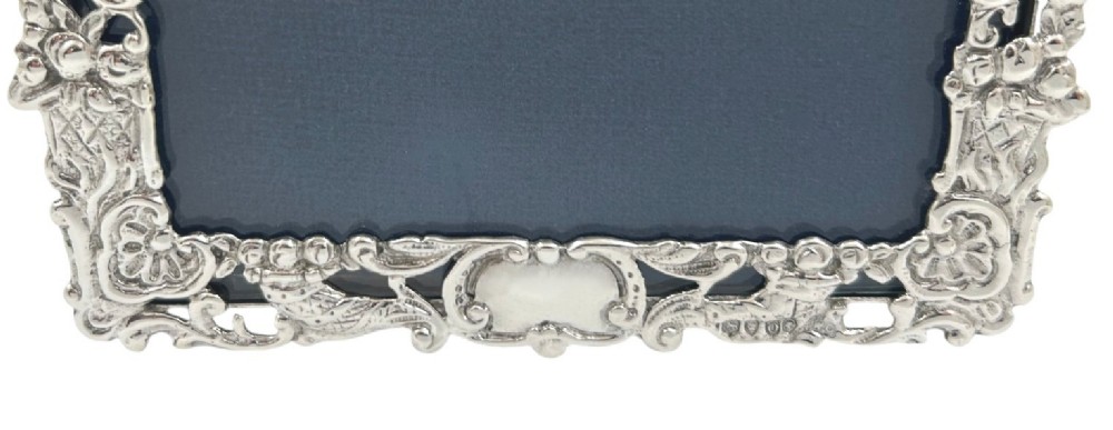 An ornate rectangular sterling silver landscape photo frame featuring detailed repousse scrollwork around the border. View VIII