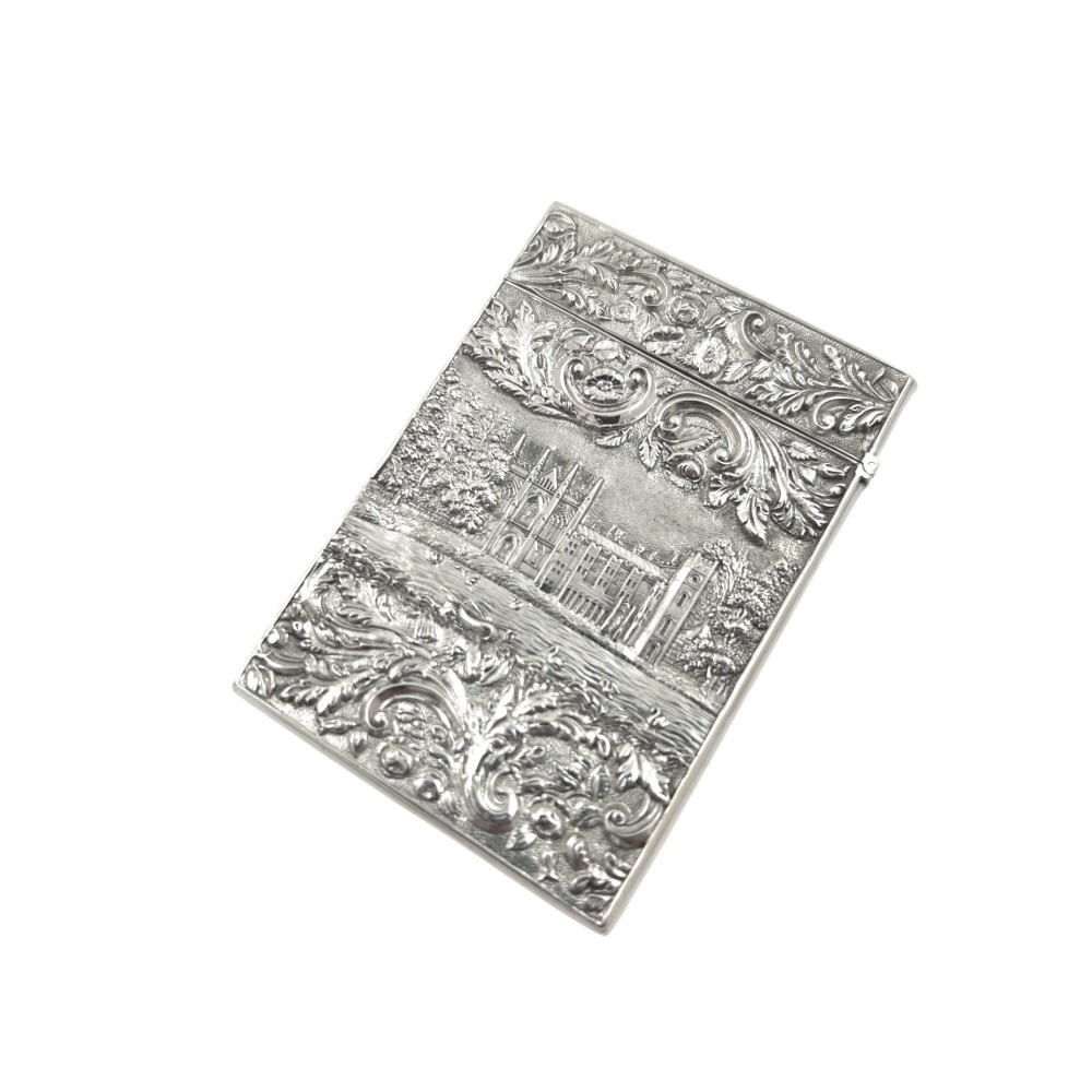 An antique sterling silver card case featuring an architectural relief depiction of Newstead Abbey framed by ornate scrollwork.