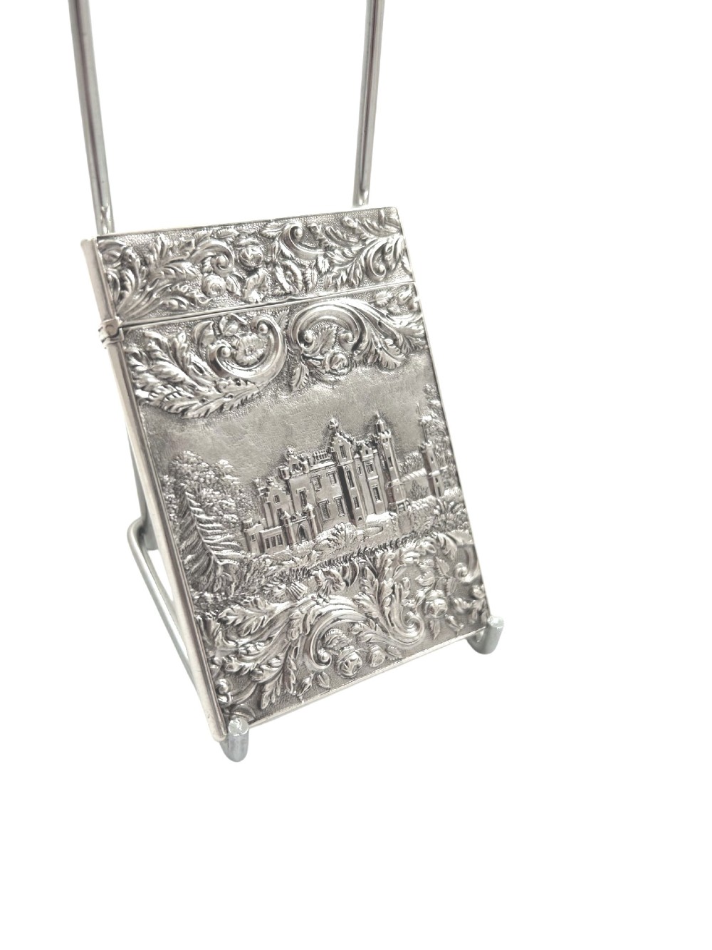 An antique sterling silver card case featuring an architectural relief depiction of Newstead Abbey framed by ornate scrollwork. View VIII