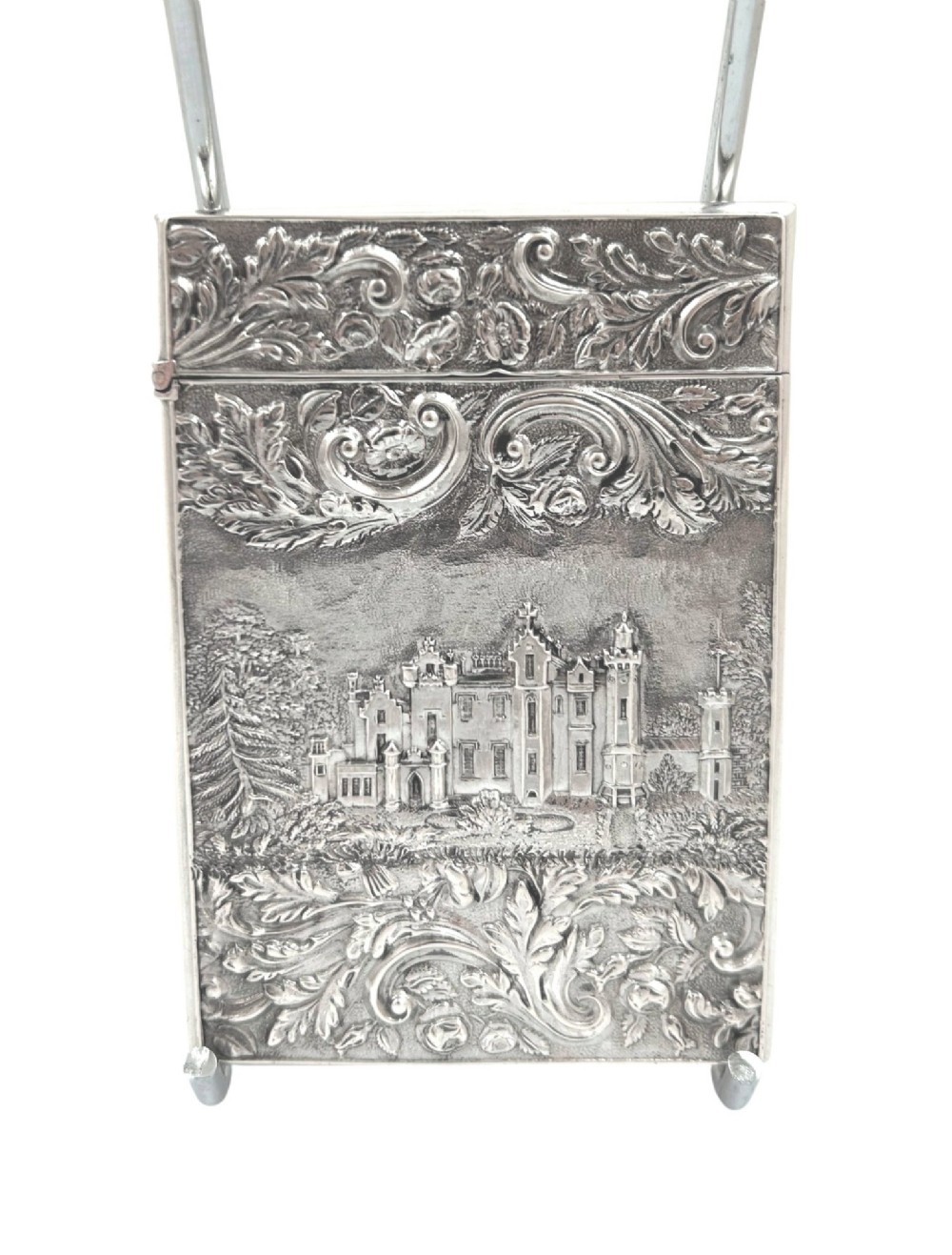 An antique sterling silver card case featuring an architectural relief depiction of Newstead Abbey framed by ornate scrollwork. View IX