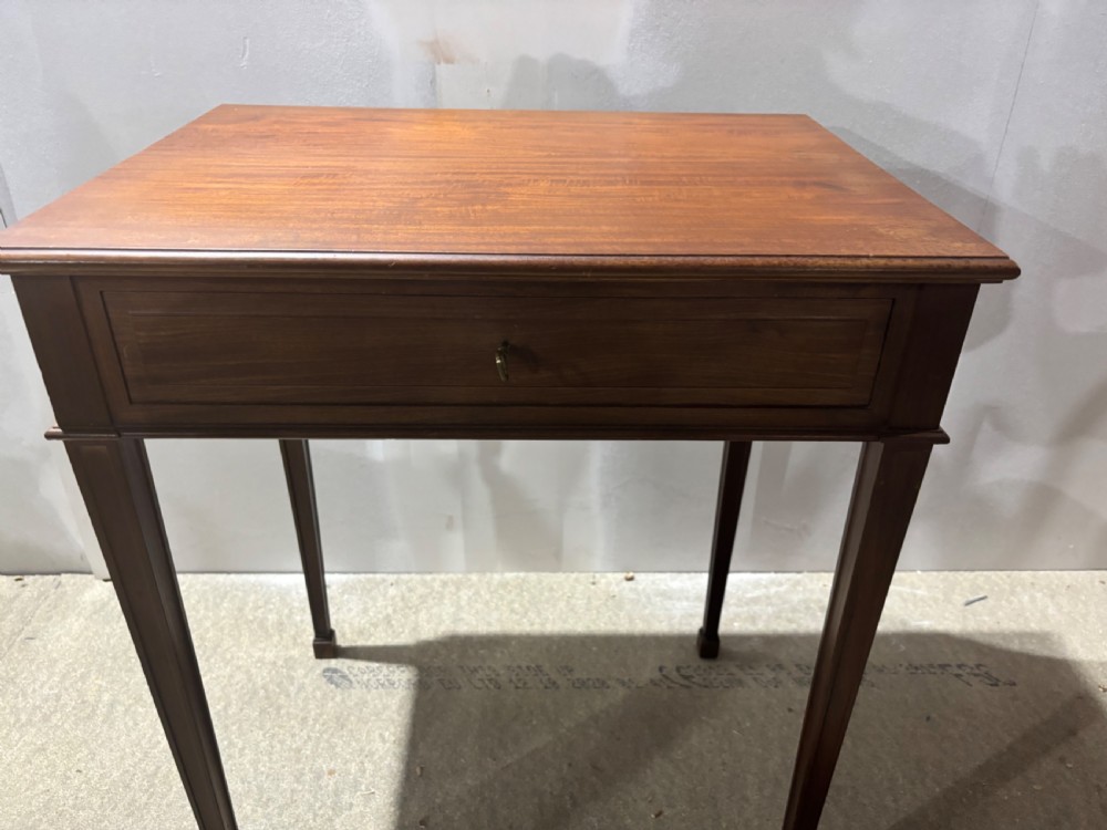 An Edwardian mahogany sewing table featuring a flat rectangular top, a single drawer with a keyhole, and four slender tapered legs.