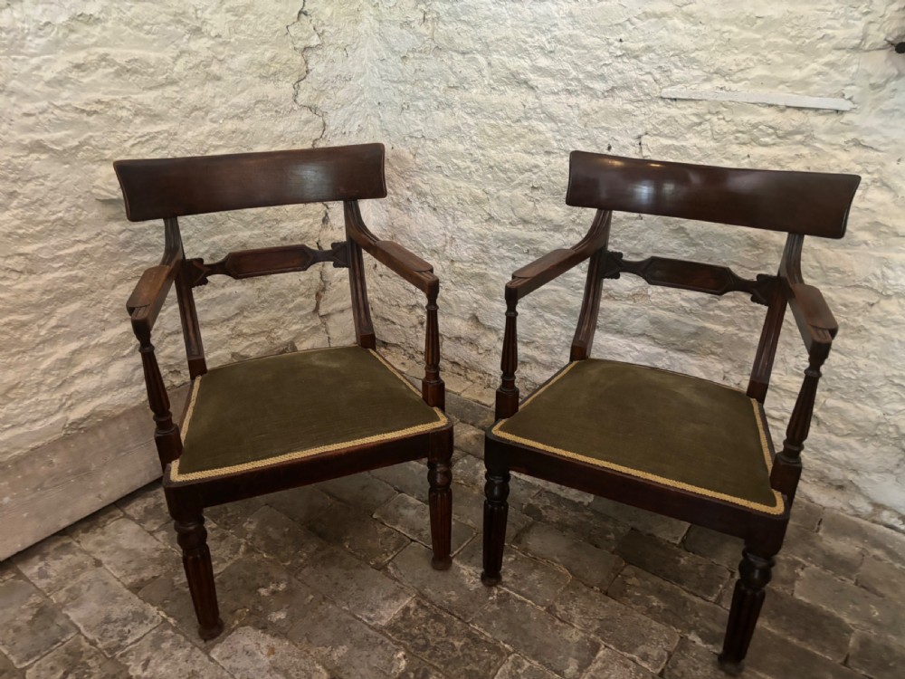 A pair of antique Regency mahogany elbow chairs featuring turned reeded front legs and olive green velvet seats. View II