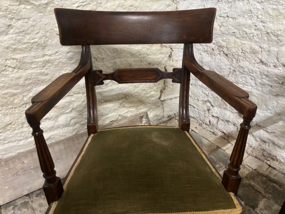 A pair of antique Regency mahogany elbow chairs featuring turned reeded front legs and olive green velvet seats. View V