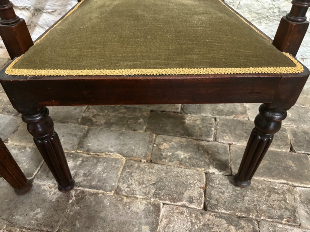 A pair of antique Regency mahogany elbow chairs featuring turned reeded front legs and olive green velvet seats. View VI