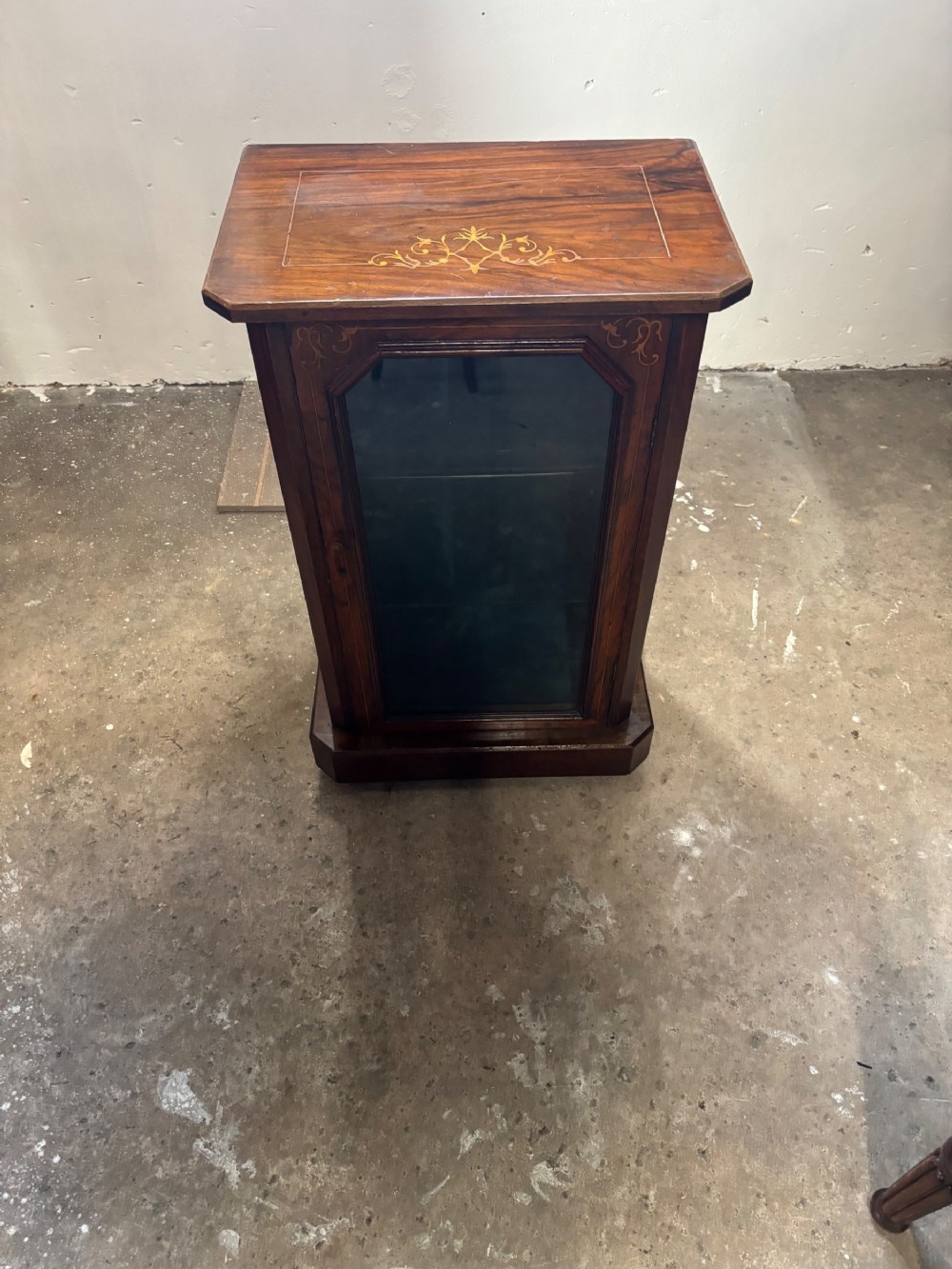 A Victorian walnut small cabinet featuring foliate marquetry inlay on the top and upper frame surrounding a single glazed door.