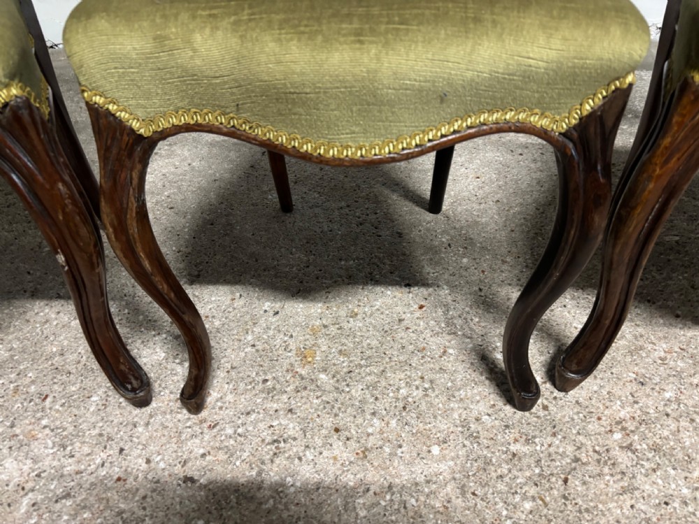 A set of three 19th-century Victorian rosewood balloon back dining chairs featuring carved crest rails, olive green upholstered seats, and cabriole front legs. View III
