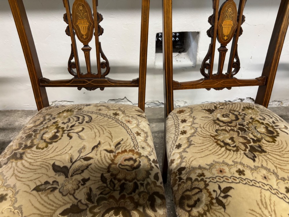 A set of four Edwardian rosewood salon chairs featuring floral pattern upholstery, turned front legs, and central urn marquetry inlays on the backrests. View IV