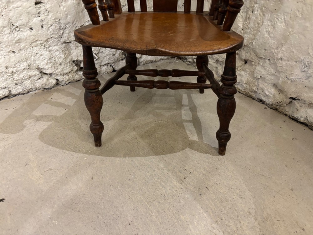 A Victorian beech and elm Windsor armchair featuring a curved top crest rail, a pierced central splat flanked by spindles, turned arm supports, and a shaped solid seat. View II